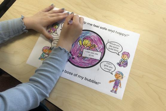 A person sitting colouring in a drawing