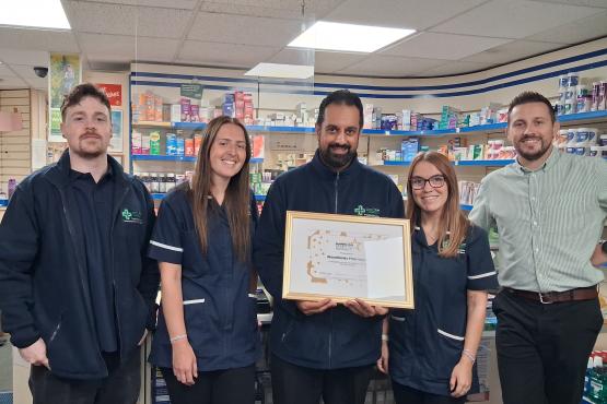 People standing looking at the camera holding a certificate