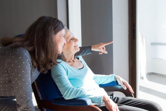 Positive mother and daughter enjoying the view out of a window Positive mother and daughter enjoying the view out of a window