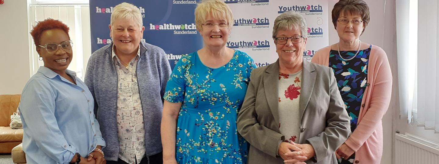 Healthwatch Volunteers standing and looking at the camera