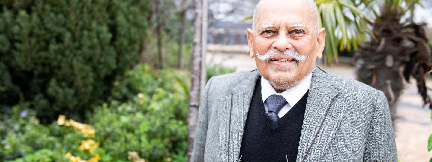 Man smiling stood outside in a courtyard