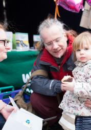 Healthwatch volunteer speaking to a grandparent and child at an event