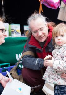 Healthwatch volunteer speaking to a grandparent and child at an event
